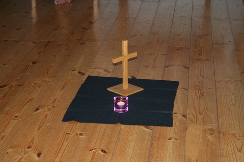 Kors på golvet med en brinnande ljus